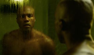 Yahya Abdul-Mateen II looking surprised at his reflection in The Matrix Resurrections.