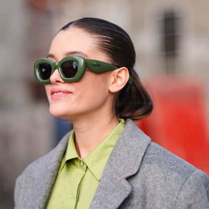 brunette woman wearing green loewe sunglasses