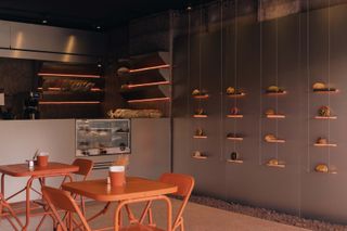 Inside the Mexico City bakery featuring the pastry wall and two two-seater tables.