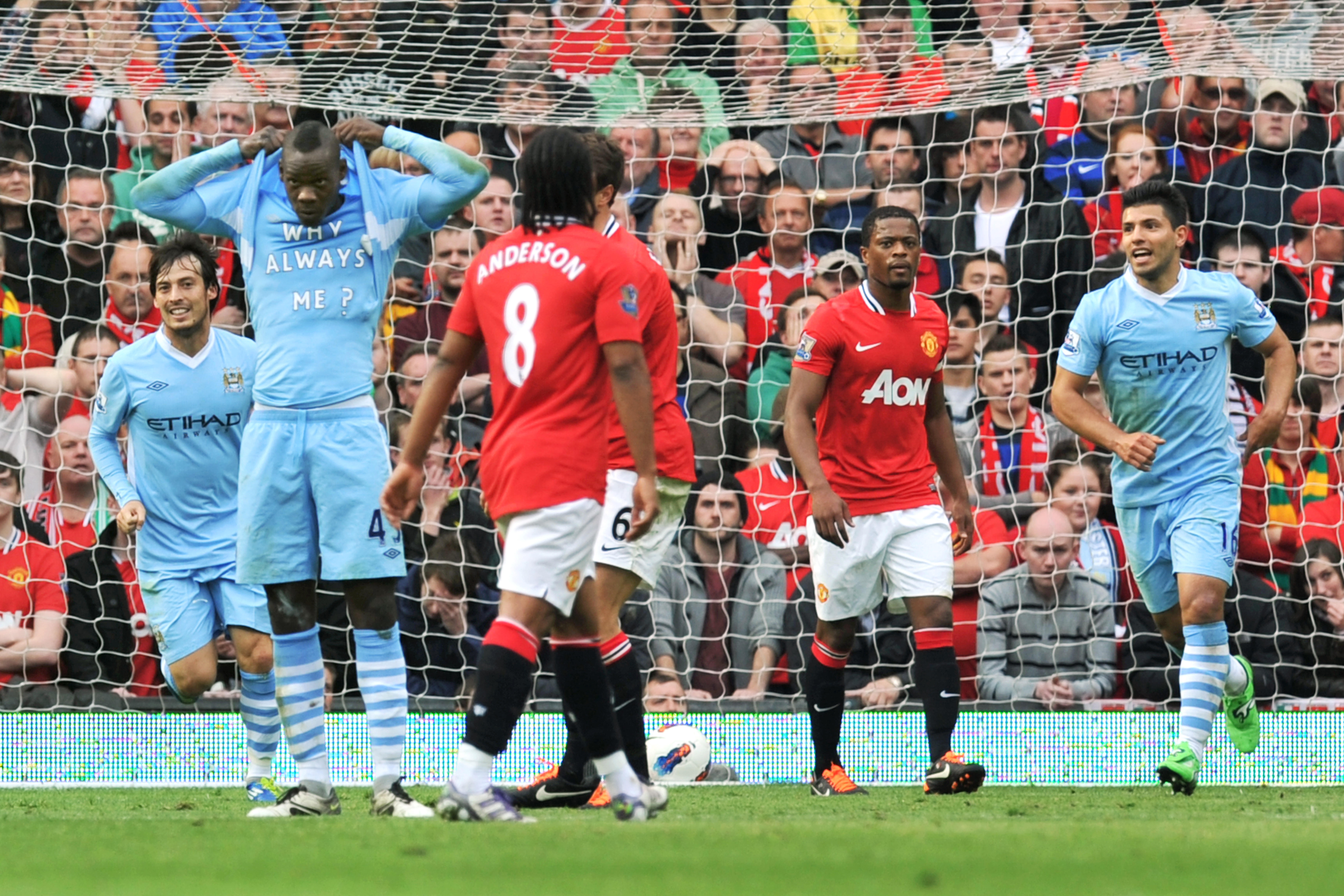 Manchester City's Mario Balotelli celebrates by revealing an undershirt bearing the message 'Why always me?' after scoring against Manchester United at Old Trafford, October 2011