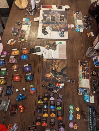 A view down a table laid out for a boss fight in the Divinity: Original Sin board game.