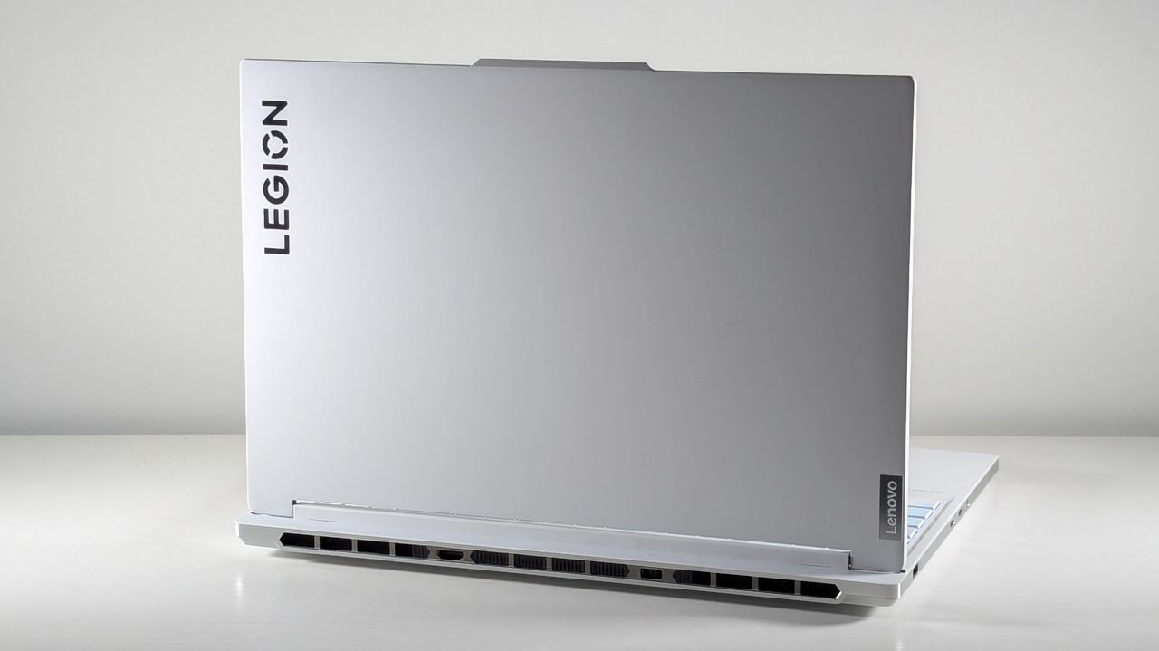 Lenovo Legion 7i Gen 9 open on a white table with its lid facing the camera. The lid is white and flat, with a little bump at the top where the webcam would be on the interior. It features a Legion logo in the top left.
