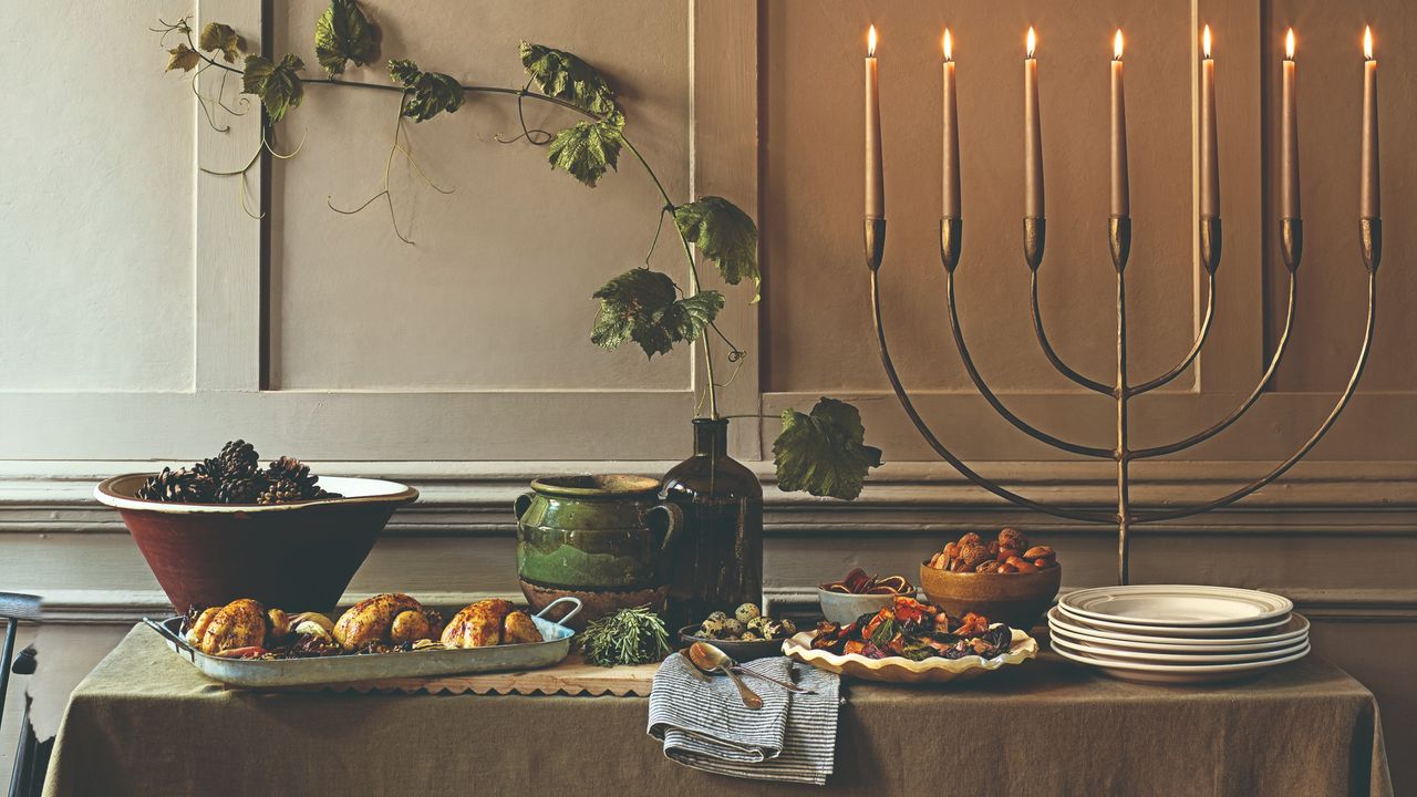 A Christmas table yet to be set with a large lit candelabra