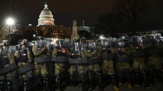 National Guard troops clear a street from protestors outside the Capitol building on Jan. 6, 2021 in Washington, D.C. 