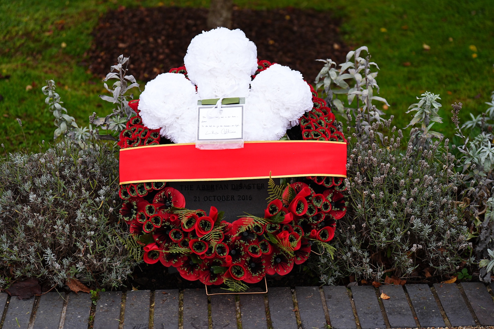 A wreath with red flowers and white feathers from Prince William and Princess Kate laid in Aberfan, Wales