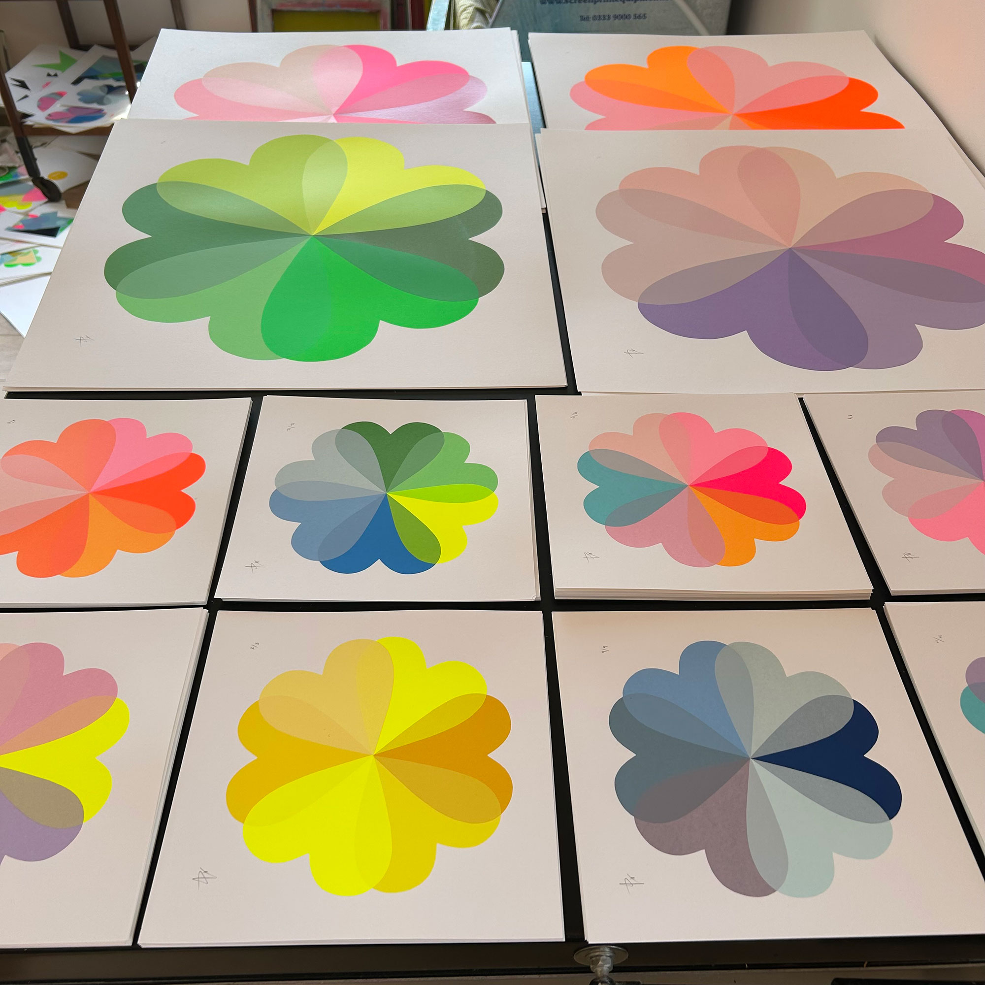 Piles of multicoloured screenprints of flowers made up of heart shapes