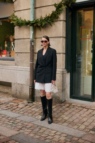 woman in blazer long white shorts knee high