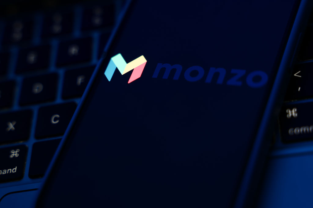 A laptop keyboard and Monzo logo displayed on a phone screen