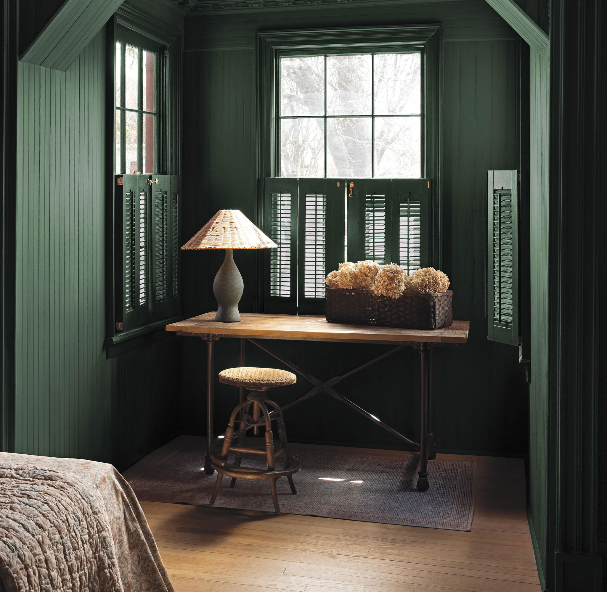 Green drenched panelled bedroom alcove with dressing table and table lamp