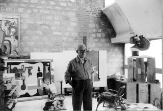 An archive photograph of Le Corbusier in his private studio at Immeuble Molitorat