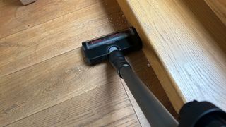 Miele DuoFlex HX1 vacuum cleaner sucking up oats near the skirting board of the reviewer's home