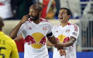 Thierry Henry celebrates with team-mate Tim Cahill after scoring for New York Red Bulls against Columbus Crew in September 2012.