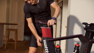 Man adjusts the seat on his Wattbike Atom