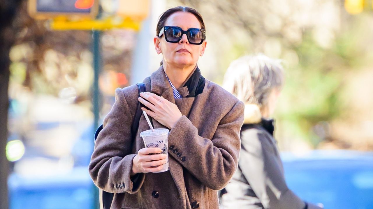 Katie Holmes walking in new york city with a reformation coat and adidas sneakers