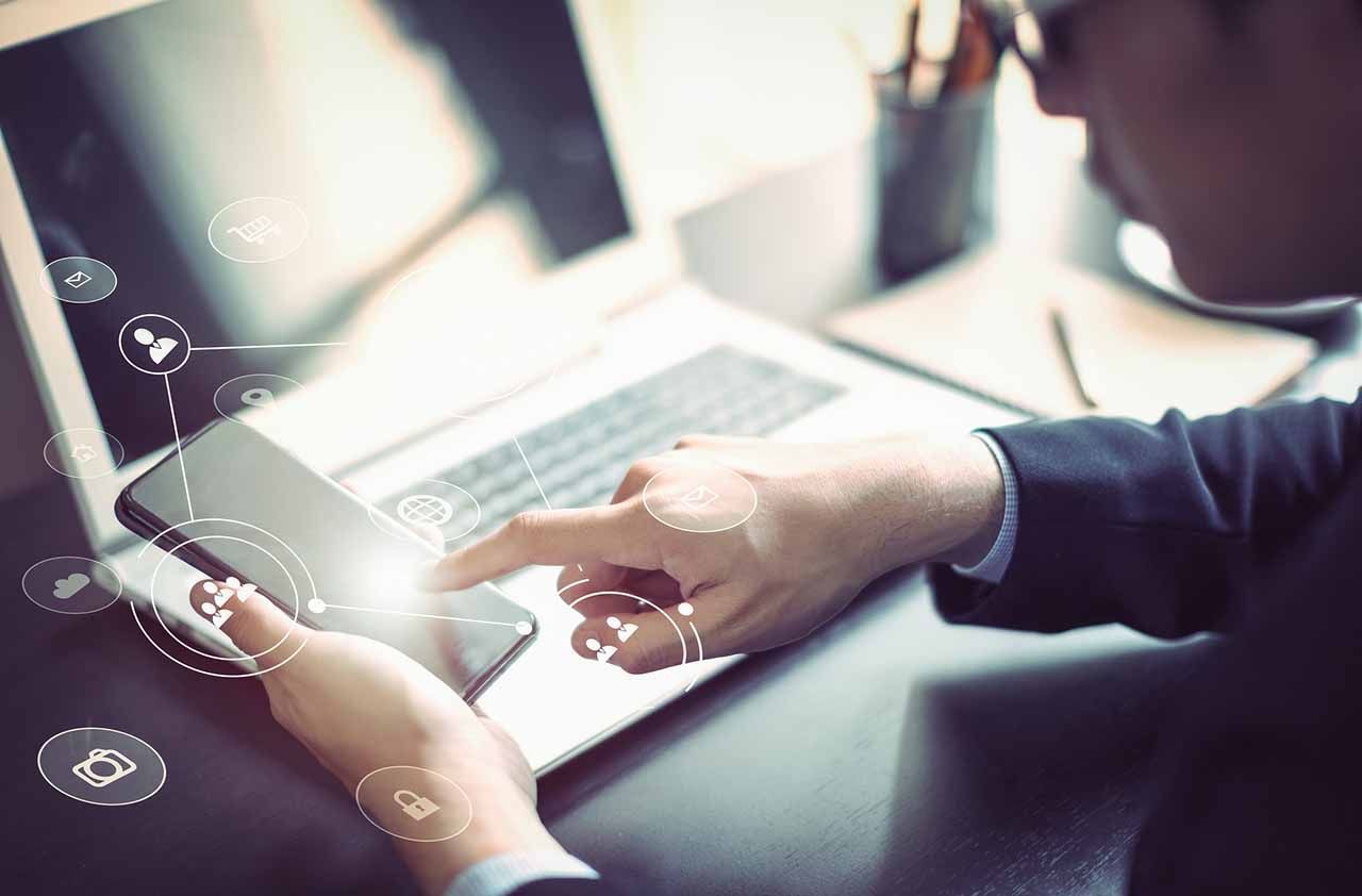 Businessman hand working with mobile phone and laptop computerwith technology digital graphic