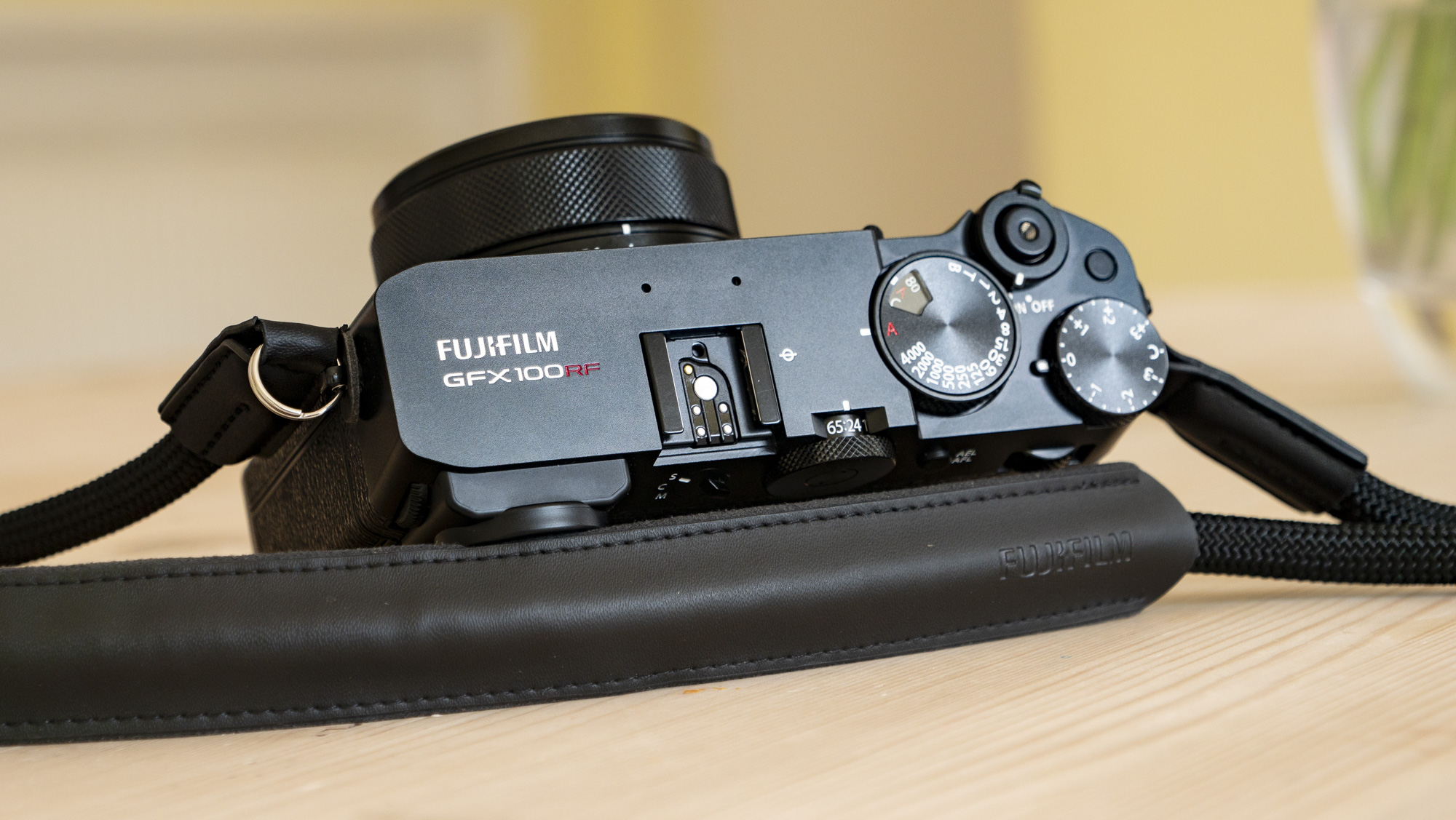 All-black Fujifilm GFX100RF rangefinder-style camera on a wooden table