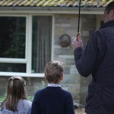 Prince William holds an umbrella over Prince George and Princess Charlotte