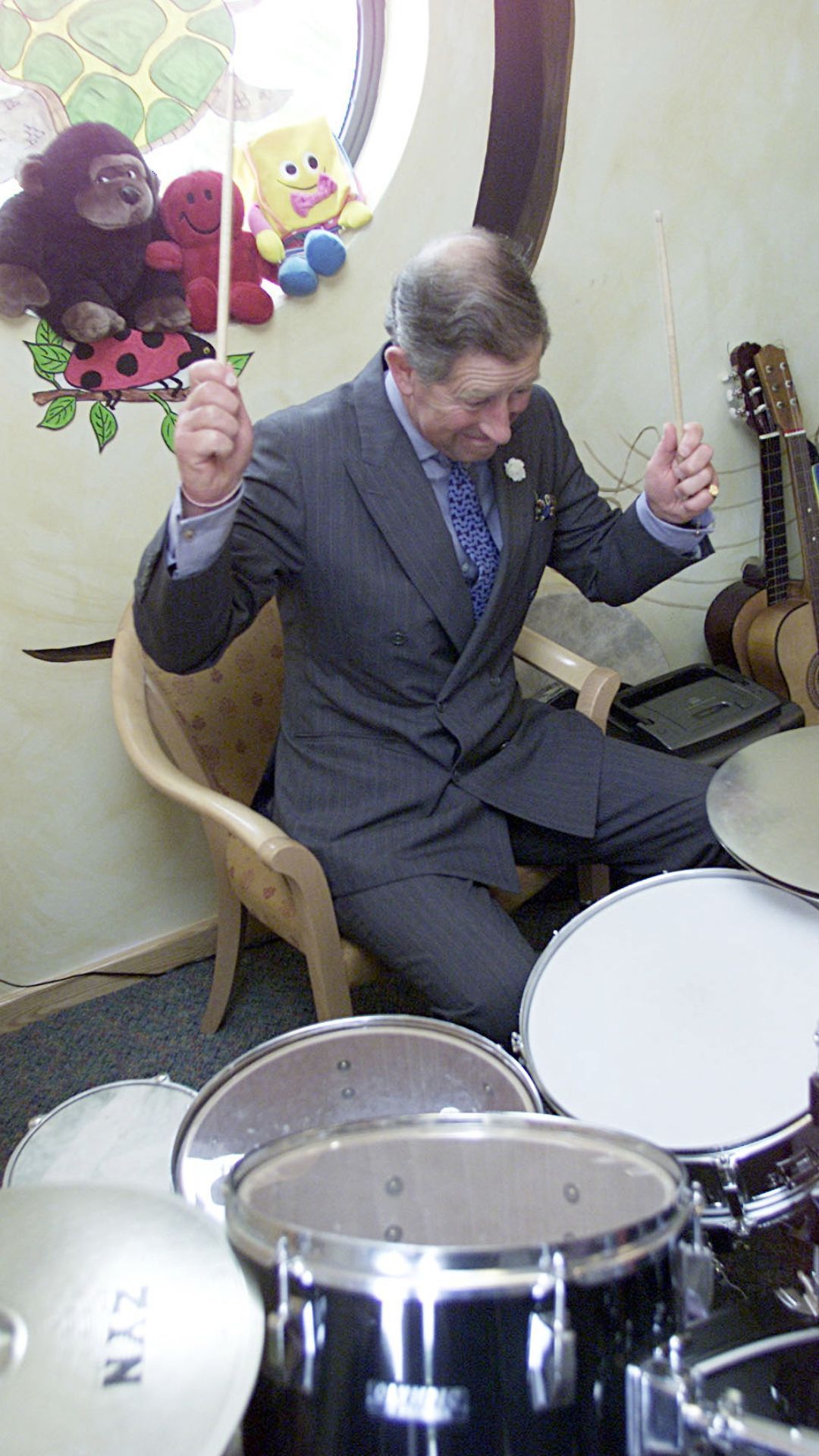 King Charles playing the drums.