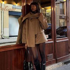 @emmanuellek_ wears a camel scarf jacket