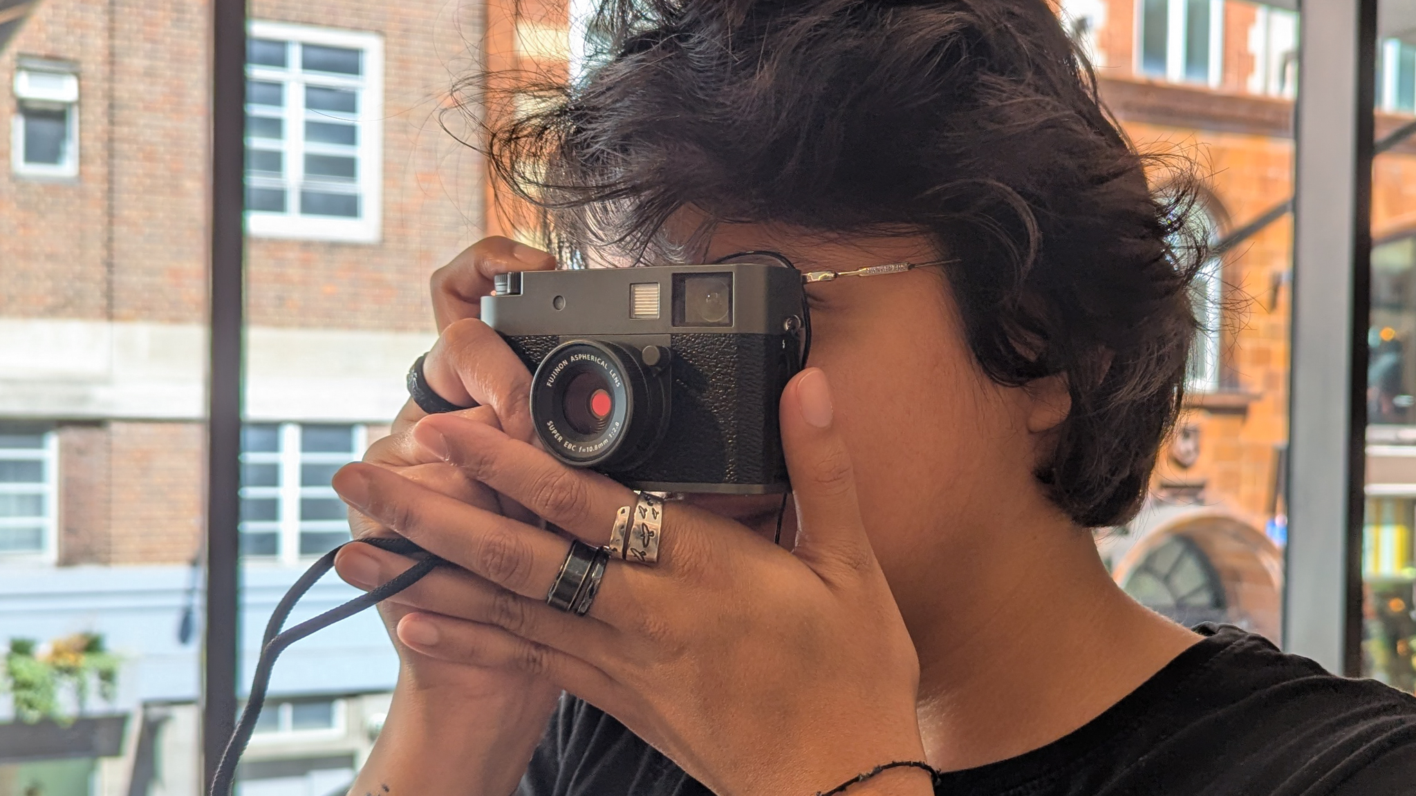 A woman holding a Fujifilm X half digital film camera