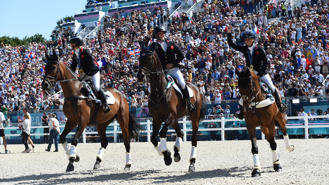 Ros Canter, Tom McEwen and Laura Collett on their lap of honour after winning team gold at the Paris Olympics