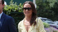 Pippa Middleton wearing sunglasses and a yellow floral dress attends Wimbledon Day 11 in 2019