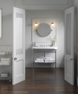 An example of bathroom shelf ideas showing a bathroom with an open vanity unit with a metal shelf under the sink