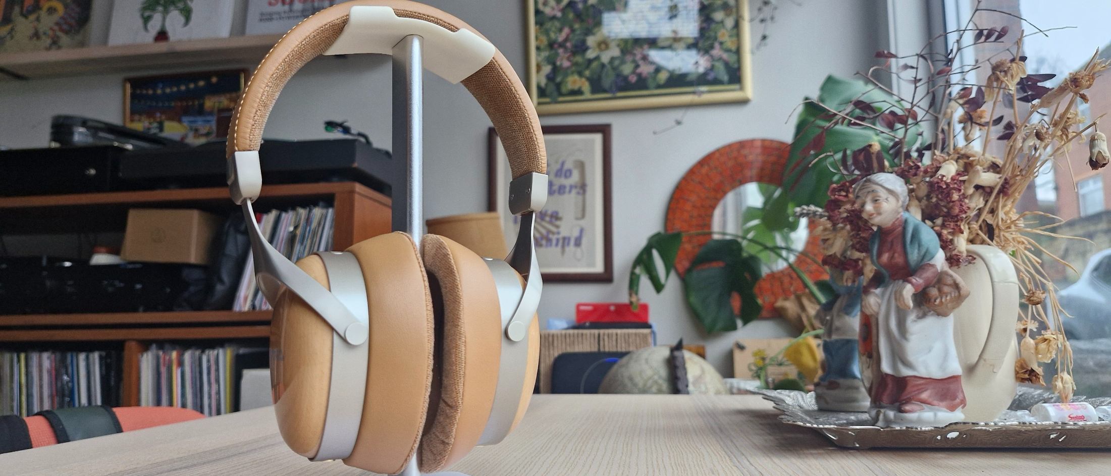 The Sivga Robin SV021 Pro over-ear closed-back headphones hanging on a stand, next to a porcelain figure.