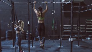 I did 100 pull ups a day for a week: person doing pull ups in a gym