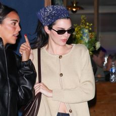 Kendall Jenner wearing a tan cardigan and dark denim jeans with a hair bandana and glove flats in L.A.