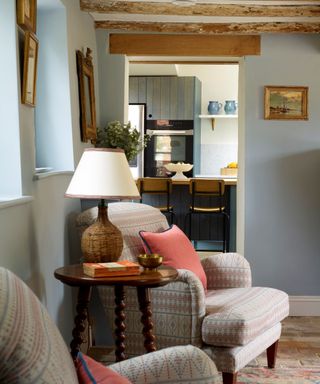 Cottage style living room area with a table lamp for ambient lighting between two upholstered armchairs