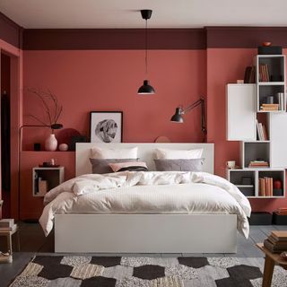 White bed frame in a red bedroom