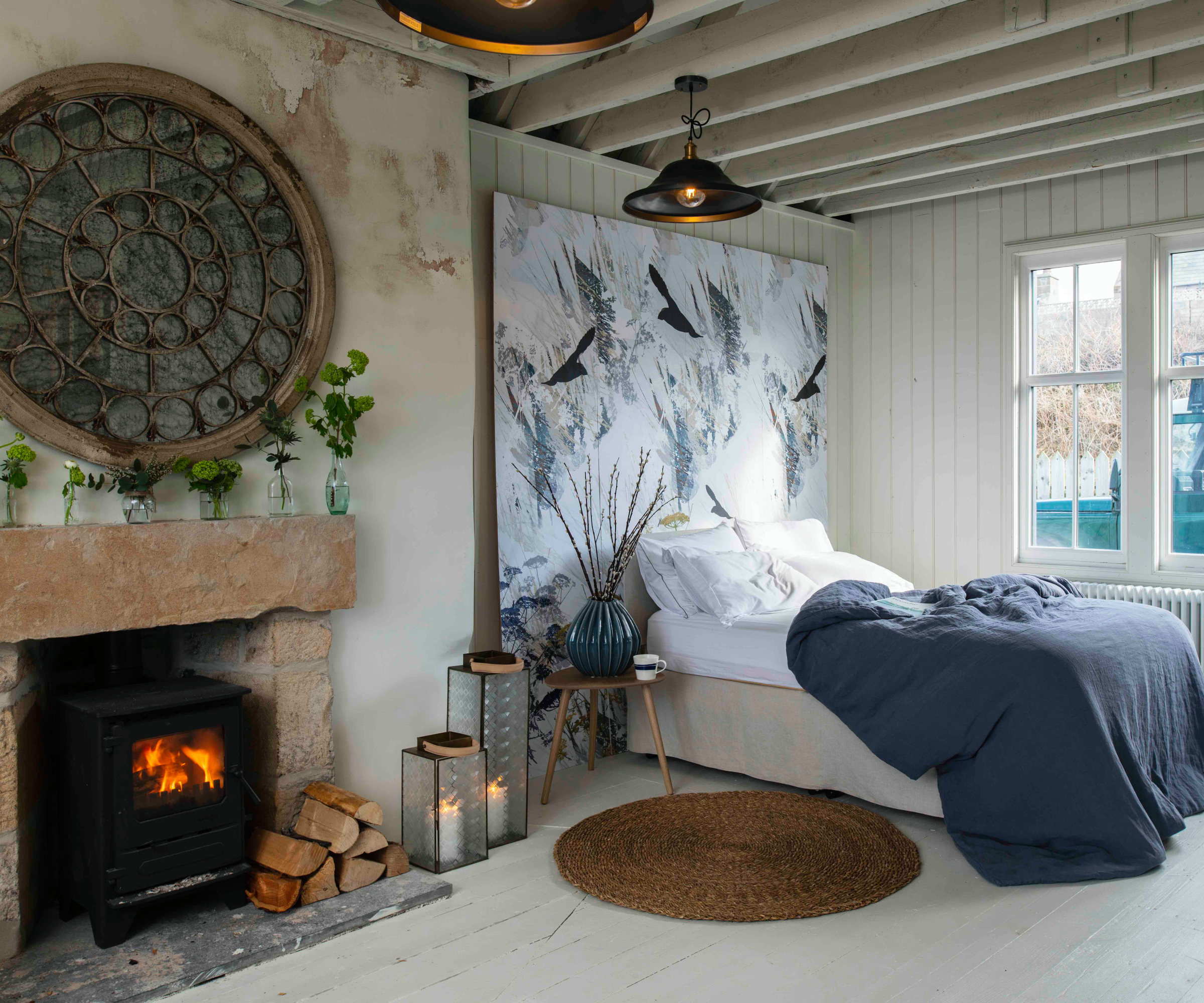bedroom with radiator under window and log burner in fireplace