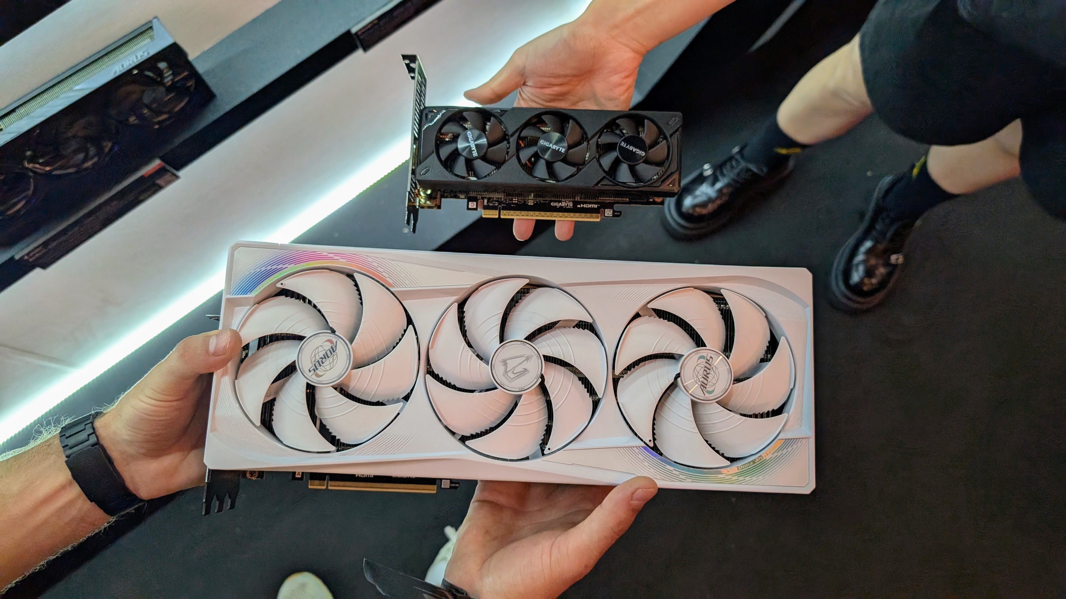 Gigabyte half height RTX 5060 held in hand and compared to the RTX 5090 at Computex 2025