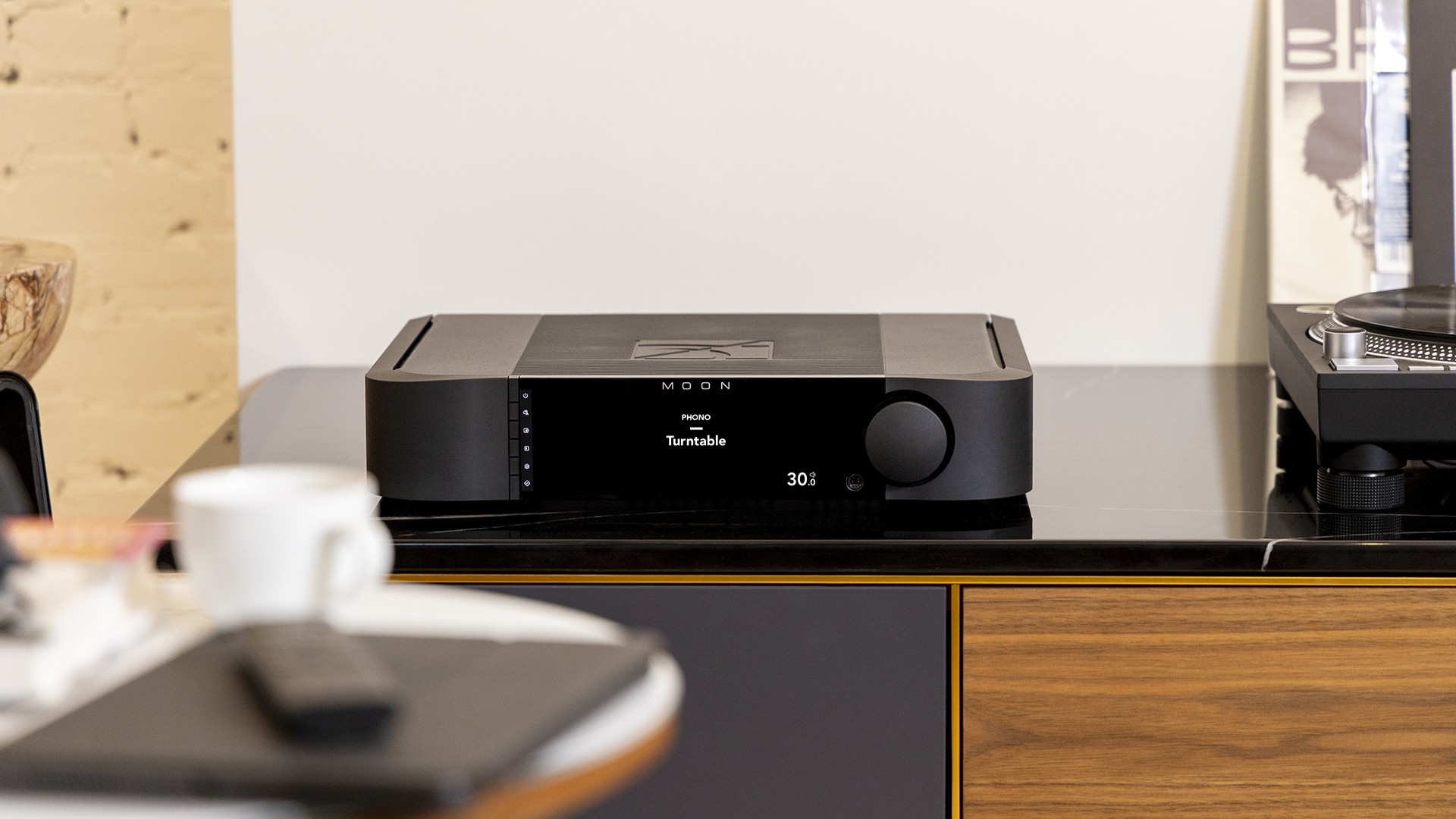 Moon 341 amplifier in black on a hi-fi rack