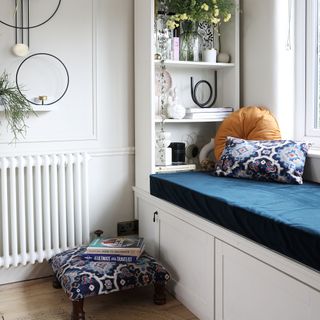 White painted room with windowsill nook, shelves, and radiator