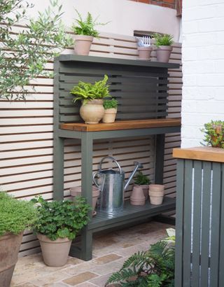 a green potting table with pots on