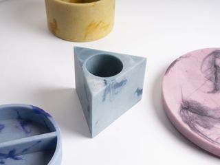 A colorful series of home accessories crafted from recycled marble dust and wool fibers presents a nostalgic palette of pastel yellows, blues, and pinks.