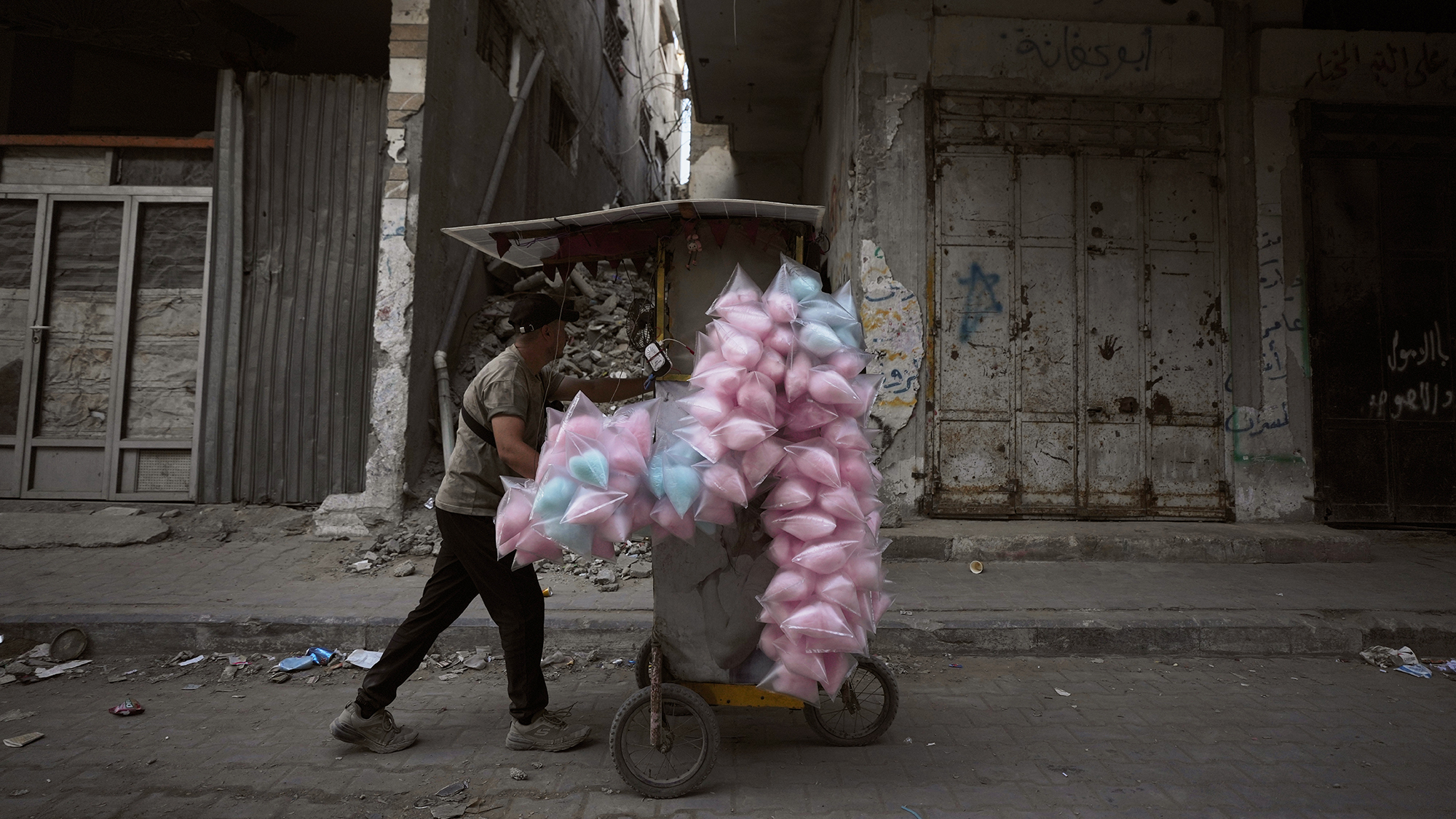A cotton candy vendor pushes his cart through the empty streets of Gaza City, Palestine