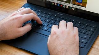 A pair of hands typing on the Google Pixelbook Go's keyboard.