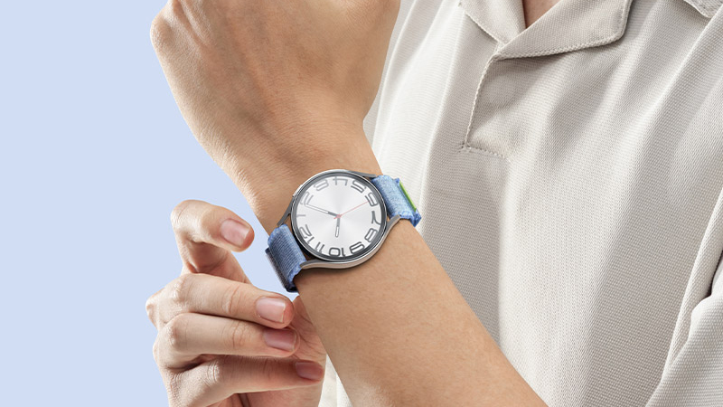 Someone wearing the Samsung Galaxy Watch 6 on their wrist in a beige polo shirt