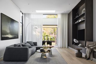 A gray interiors living room with a dark gray sofa and light gray rug