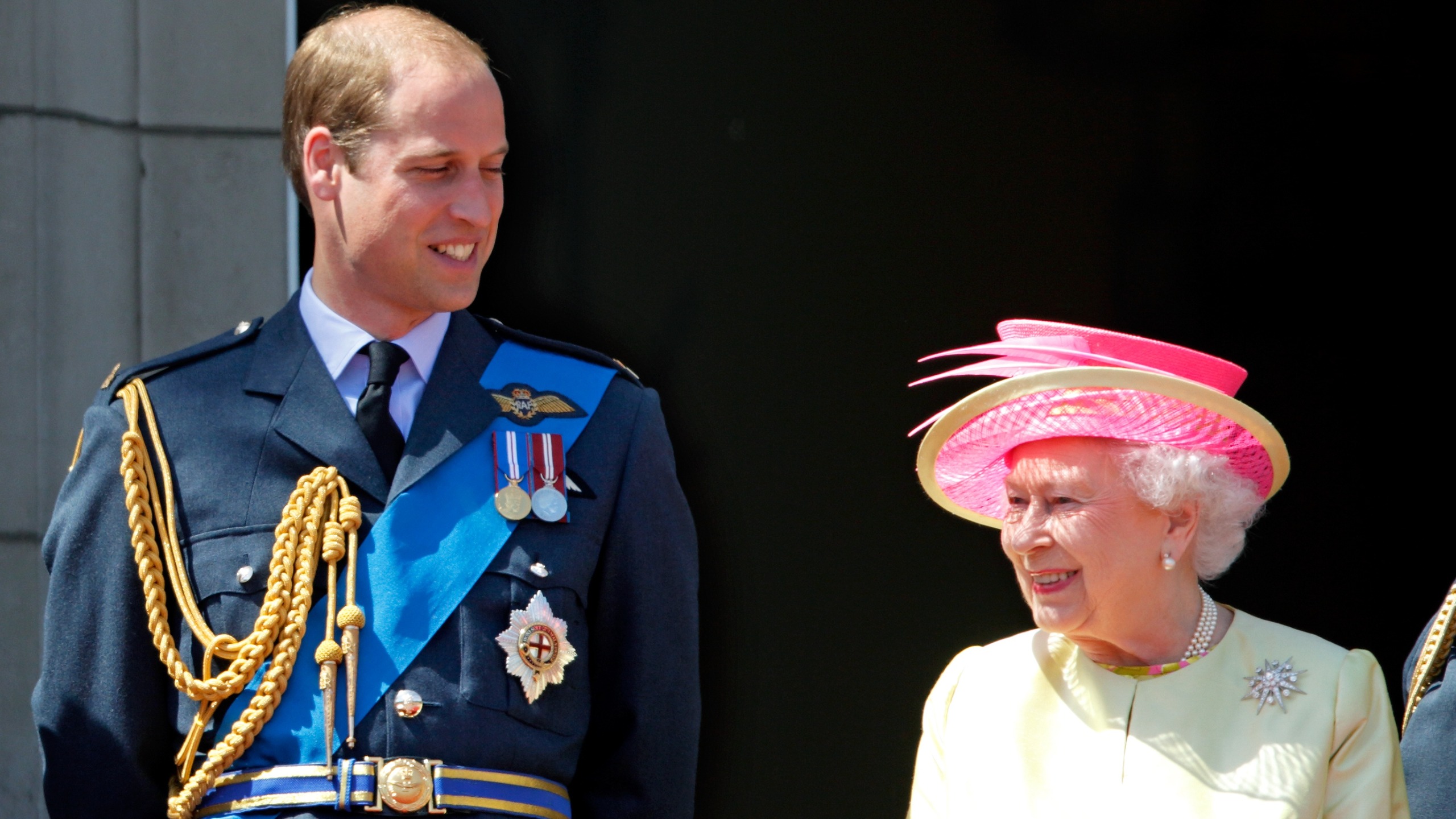 Prince William looks at Queen Elizabeth on the balcony of Buckingham Palace on July 10, 2015