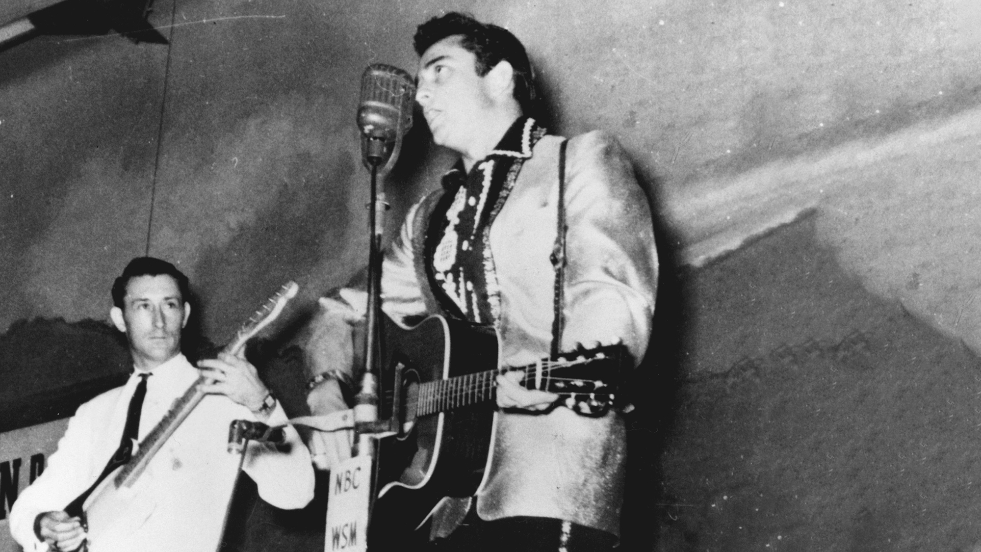 Country singer Johnny Cash performs on the WSM Grand Ole Opry tour with his band the Tennessee Two which included bassist Marshall Grant and guitarist Luther Perkins in circa 1956