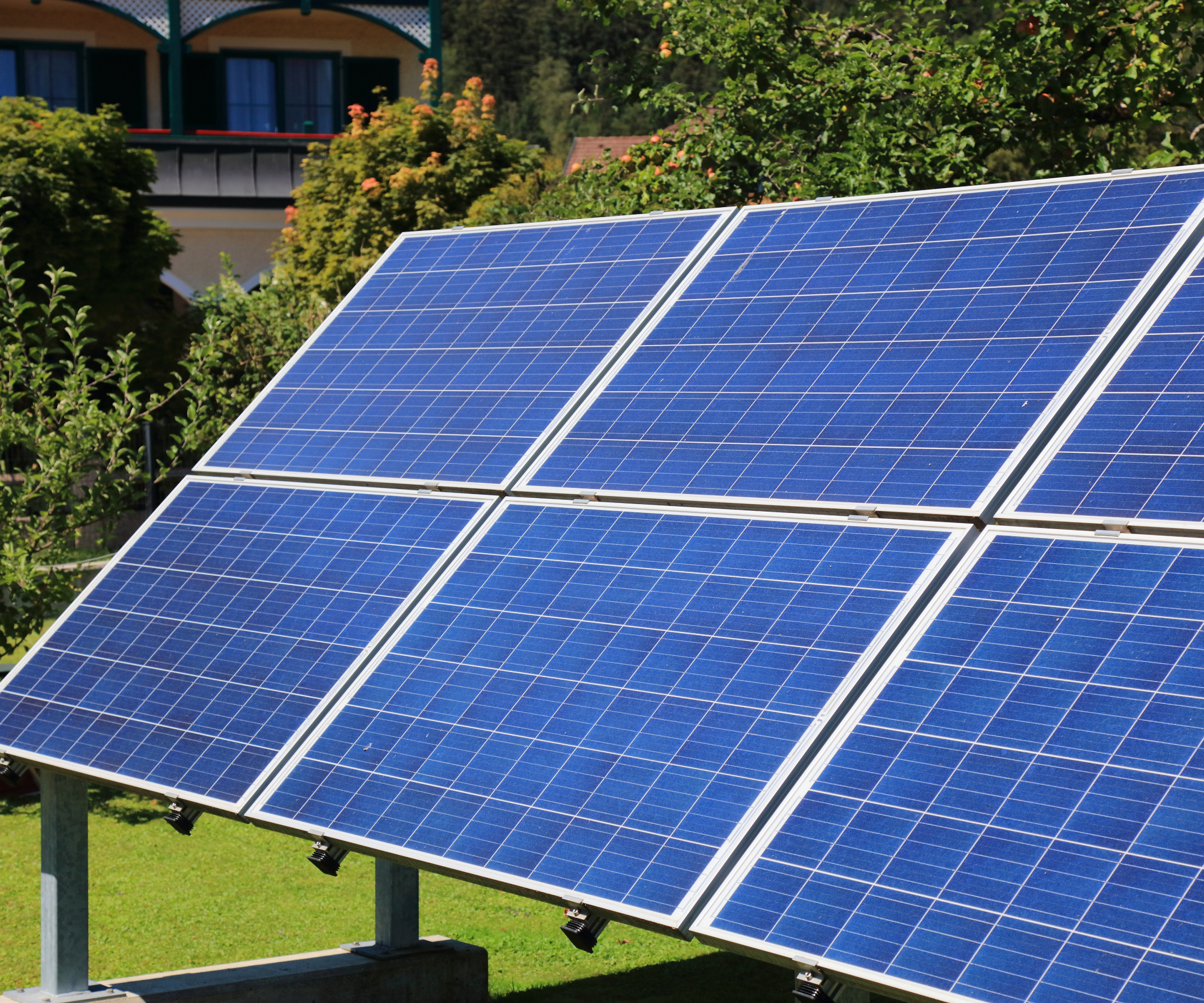 ground mounted solar panels in garden with house in background