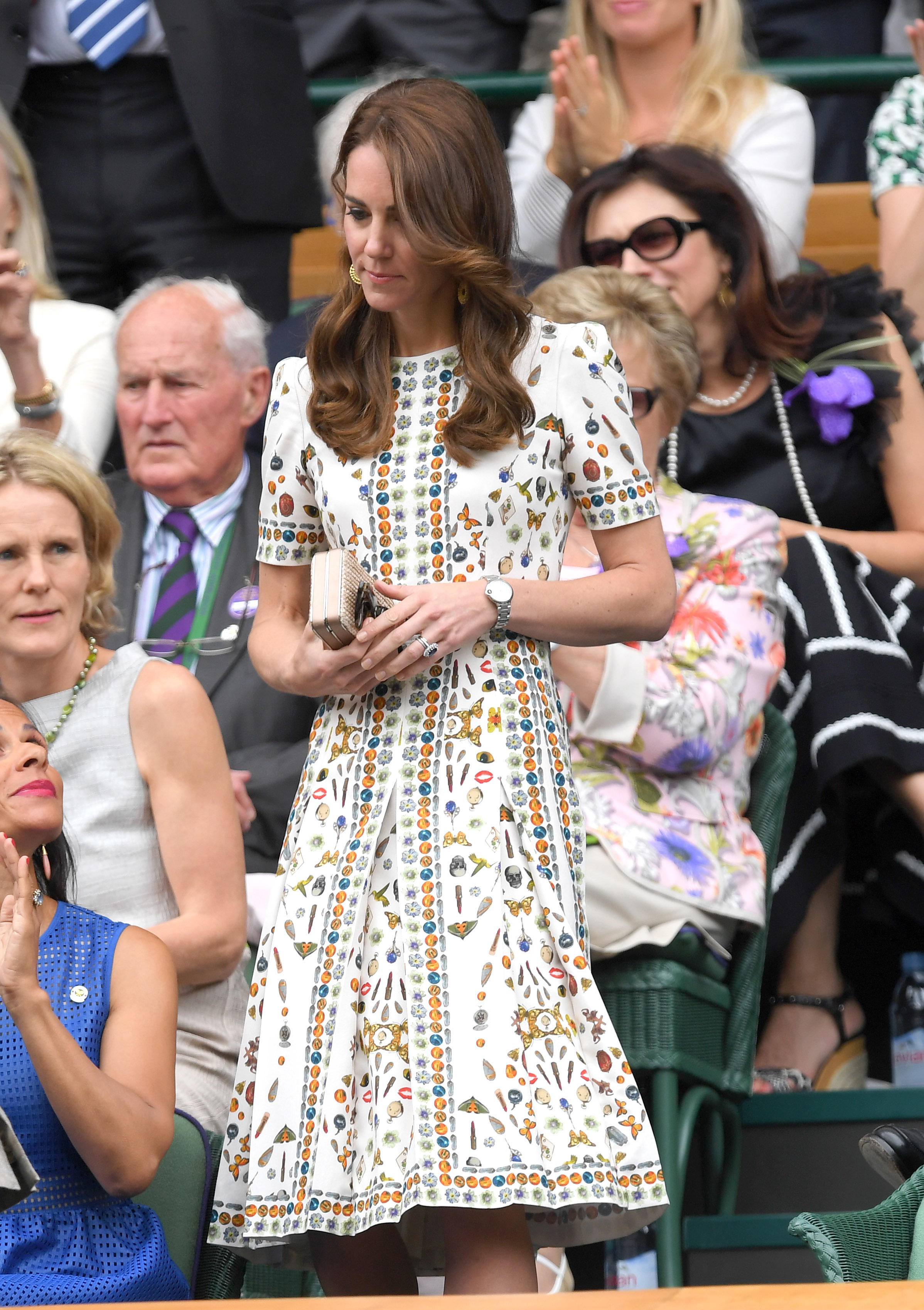 Kate Middleton wearing a white patterned dress walking to her seat at Wimbledon