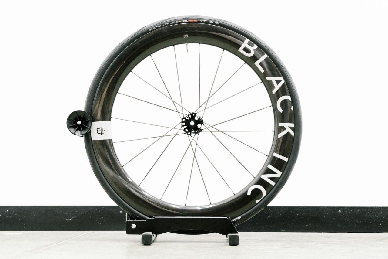 An aero road wheel stands against a white wall