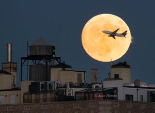 Photographer Stan Honda caught this photo of a West Jet airplane flying in front of the supermoon after taking off from LaGuardia Airport in New York on Nov. 13.