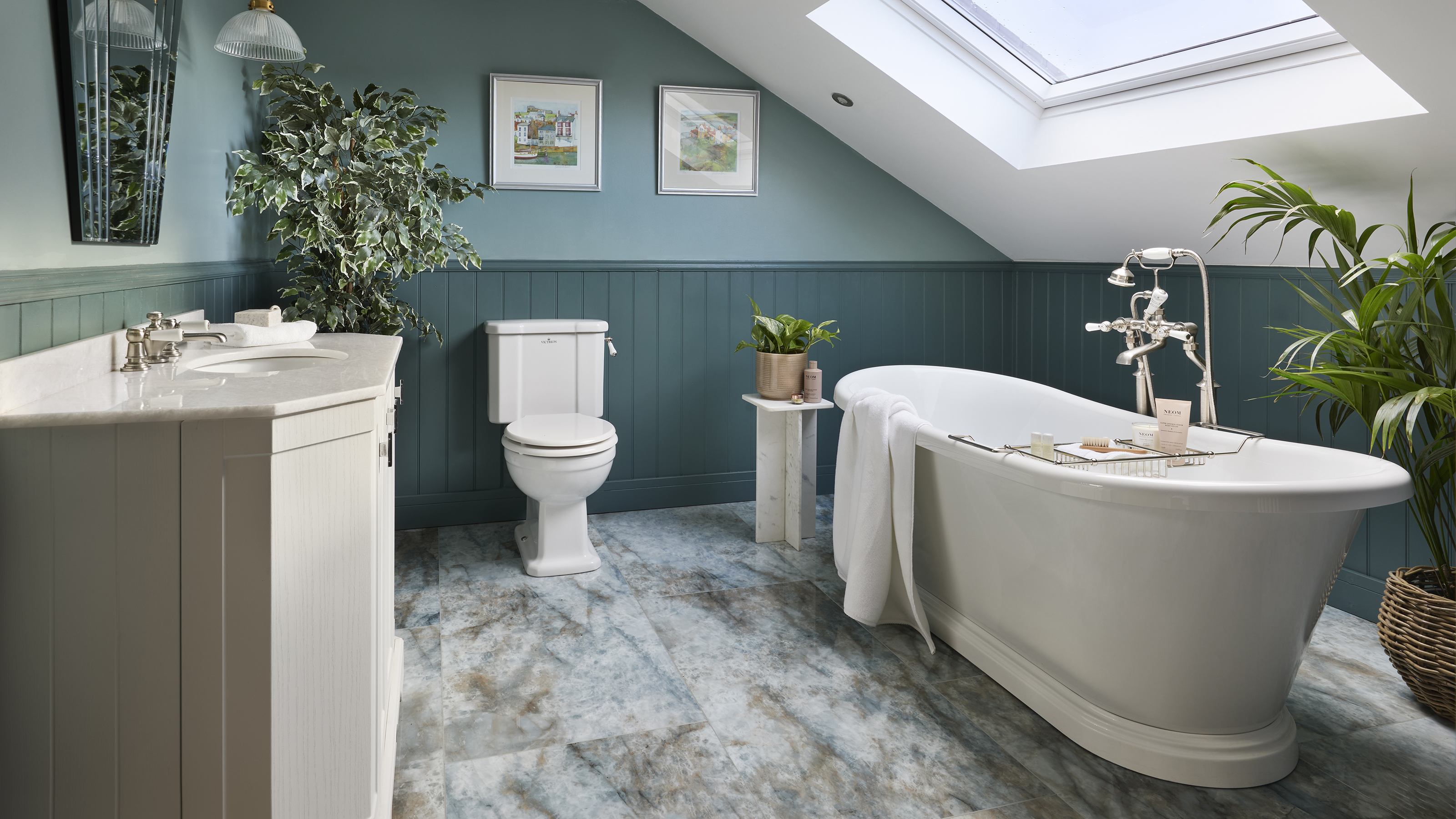 Blue bathroom with traditional white bath and stone floors