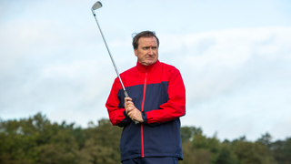 A golfer wears the Ashworth Waterproof Rain Jacket